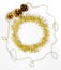 Christmas decorations of yellow and golden color on a white background - chain of balls, beads, tinsel, three bumps. New year