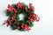 Christmas decorative wreath of holly, ivy, mistletoe, cedar and leyland leaf sprigs with red berries over white background