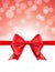 Christmas defocused bokeh background with red bow. Gift card holiday celebration invitation xmas