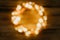 Christmas defocused lights in the shape of a circle on a wooden background. Festive creative cozy background. Copy space