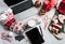 Christmas desktop with laptop, tablet and smart phone surrounded by stockings, candy canes and coffee, top view flat lay