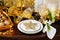 Christmas dinner background, plate, fork, knife and festive decoration on dark rustic wooden table, top view. Table setting with