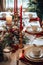 Christmas dinner table decorated with gold and red decorations by Generative AI