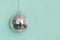 Christmas disco ball hanging on green. Creative Xmas pattern with copy space.