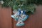 Christmas door decoration. Holiday bells hanging from pine wreath. Wooden texture background