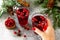 Christmas drinks. Female hand holding of Hot winter drink with cranberries and cinnamon