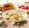 Christmas dumplings stuffed with forest mushrooms and cabbage on a white plate on a holiday table.