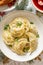 Christmas dumplings stuffed with forest mushrooms and cabbage on a white plate on a holiday table.