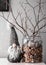 Christmas dwarf and a jar of pebbles and branches on a white table against the wall