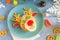 Christmas edible deer of buns and marmalade on a blue plate on the holiday table next to candy, snowflakes and branches
