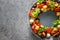Christmas edible wreath of holiday snacks, canapes, tomatoes, olive, vegetables, cheese