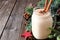 Christmas eggnog in a mason jar with branches and decorations on wood