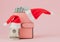 Christmas expenses. Pink leather purse with santa claus cap, gift, fir tree and dollars banknotes on pink background. Christmas sh