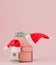 Christmas expenses. Pink leather purse with santa claus cap, gift, fir tree and dollars banknotes on pink background. Christmas sh