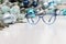 Christmas eyeglasses blue spectacles isolated on white table with balls and decorations useful as a greeting gift card template