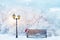 Christmas fabulous image. Lantern, bench and cap of Santa Claus in the winter city park. Winter landscape.