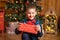 Christmas fabulous, little boy holding a big red box with a present from Santa