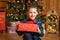 Christmas fabulous, little boy holding a big red box with a present from Santa