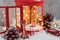 Christmas fairy composition of red lantern with Christmas tree and lights inside, decorative skis, sledges with decorations, cones