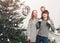 Christmas family with baby smiling near the Xmas tree. Living room decorated by Christmas tree and present gift boxes, the light