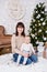 Christmas and family concept - happy young mother and cute little baby girl near decorated christmas tree