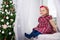 Christmas and family concept - little girl and decorated Christmas tree