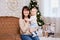 Christmas and family concept - mother and cute little baby girl daughter near decorated christmas tree