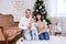 Christmas and family concept - young parents and cute little baby girl daughter near decorated christmas tree