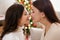 Christmas, family, love and motherhood concept - happy mother and her cute daughter in decorated living room with Christmas tree