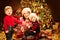 Christmas Family, Mother with Children front of Xmas Tree Lights, Happy Mom and Baby