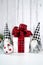 Christmas Farmhouse style background with red plaid bow gift and gnomes.