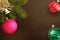 Christmas fir branch, pink, red wavy and green ribbed ball, decorative bell on dark