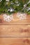 Christmas fir tree with snow and snowflake decor on rustic wooden board