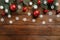 Christmas flat lay composition. Fir tree branches decorated red baubles and snowflakes on wooden table. Xmas postcard, New Year