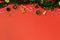 Christmas flat lay, tinsel, gingerbread, cookie cutter, candy cane, dried orange, ornaments, pinecone on red background