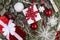 Christmas foliage composition with red and white gifts with ribbon, globes, snow flakes, berries, snowy fir branches, top view