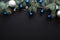 Christmas frame border with blue and sliver modern decorations, baubles, fir tree branches on dark black background. Elegant