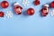Christmas frame top border of red balls, decorations, santa gloves, snowflakes on blue background. Christmas, winter holidays, New