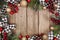 Christmas frame with white and black checked buffalo plaid ribbon, baubles and branches, top view on a wood background