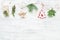 Christmas garland of conifer branches & christmas decorations on white wooden background, copy space