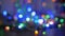 The Christmas garland is flashing with colored lights. Beautiful fuzzy background. Movement of the camera around the