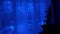 Christmas Garland of Many Blinking, Flickering Blue LED Lights on Curtain.