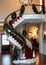 Christmas Garland Wrapped Around A Spiral Staircase, In A Grand Foyer. Generative AI