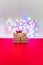 Christmas gift box on the red surface with boke background. New Year celebration.