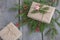 Christmas gift box on wooden table, handicraft wrapping, parchment, twine, fir tree twigs, cute simple last minute present handmad