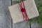 Christmas gift box on wooden table, handicraft wrapping, parchment, twine, fir tree twigs, cute simple last minute present handmad