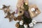 Christmas gift boxes with flowers and decorative objects Eco cotton, cinnamon, spruce branches and jute rope hank over white backg