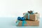 Christmas gift boxes wrapped of craft paper, blue and white ribbons, decorated of fir branches and Christmas balls.