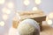 Christmas gift boxes wrapped in craft paper tied with twine linen fabric ornament ball on wooden chair. Golden garland bokeh light