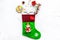 Christmas gift concept, christmas surprises. Traditional festive socks filled with gift box, sweets, winter decor on